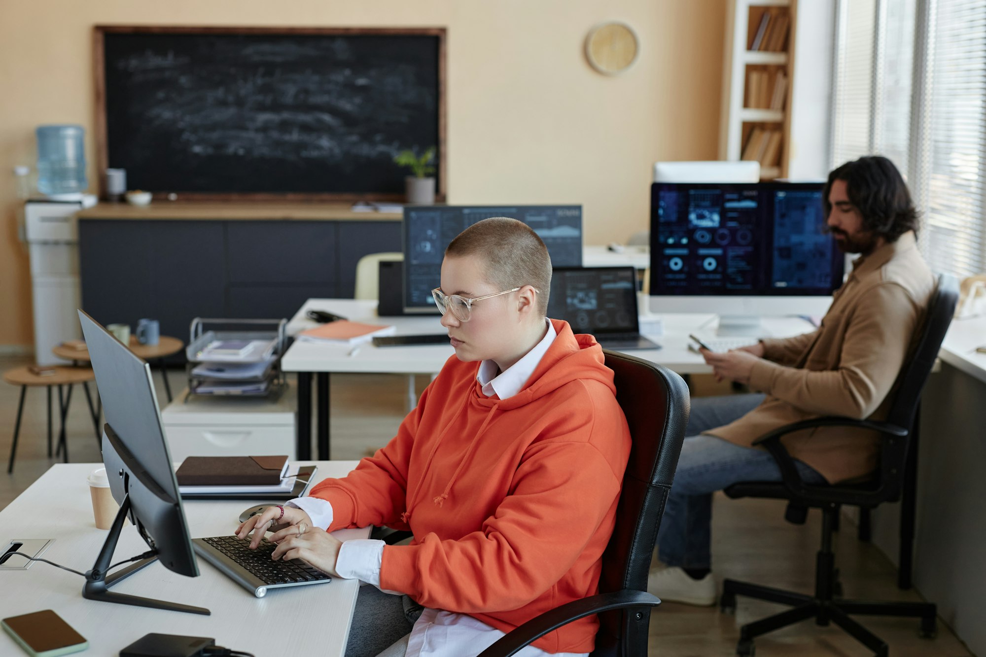 Side view of young busy female specialist in cyber security networking